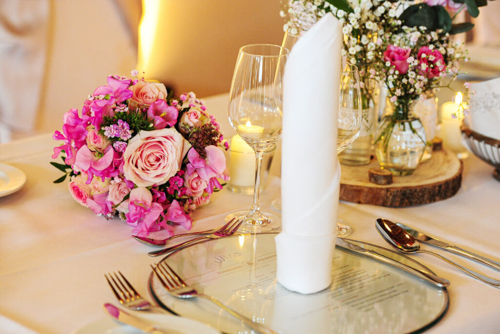 Tisch mit Blumen und Glasuntersetzer